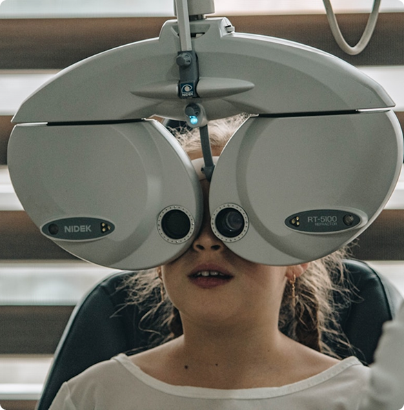 Child undergoing eye examination with phoropter